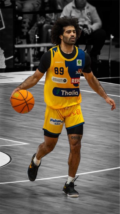 Basketballspieler dribbelt mit Ball, trägt gelb-blaues Trikot, schwarze Shorts.