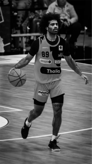 Basketballspieler dribbelt den Ball auf dem Spielfeld.