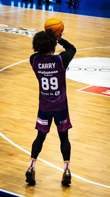 Spieler mit der Nummer 89 bereitet sich auf einen Wurf im Basketballspiel vor.
